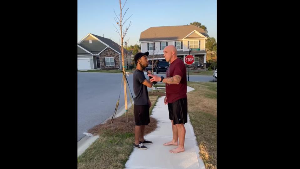 Jonathan Pentland confronts a black man on a sidewalk outside a home.