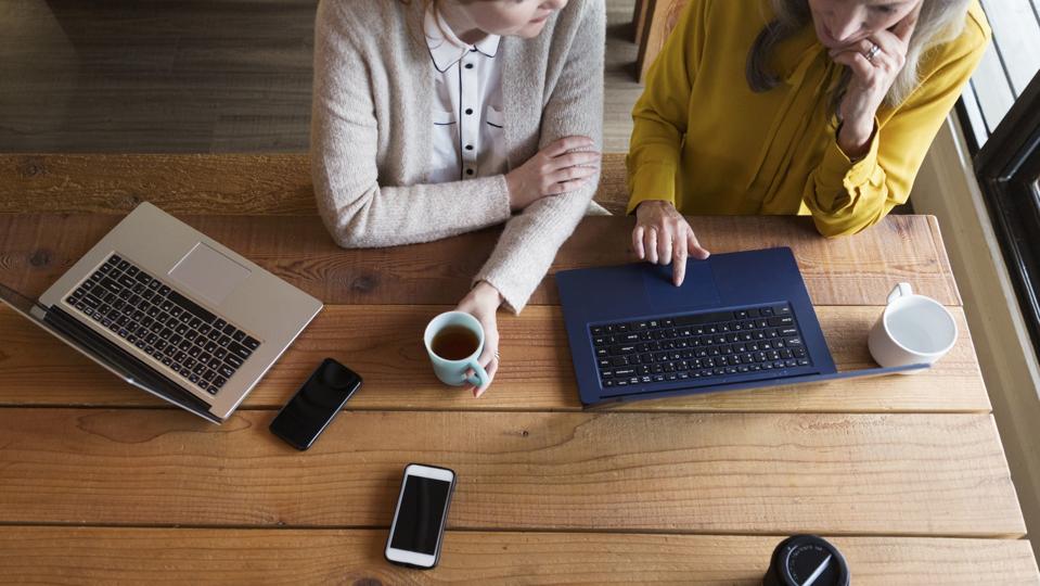 Pengusaha wanita kreatif mengadakan pertemuan informal di kantor terbuka modern