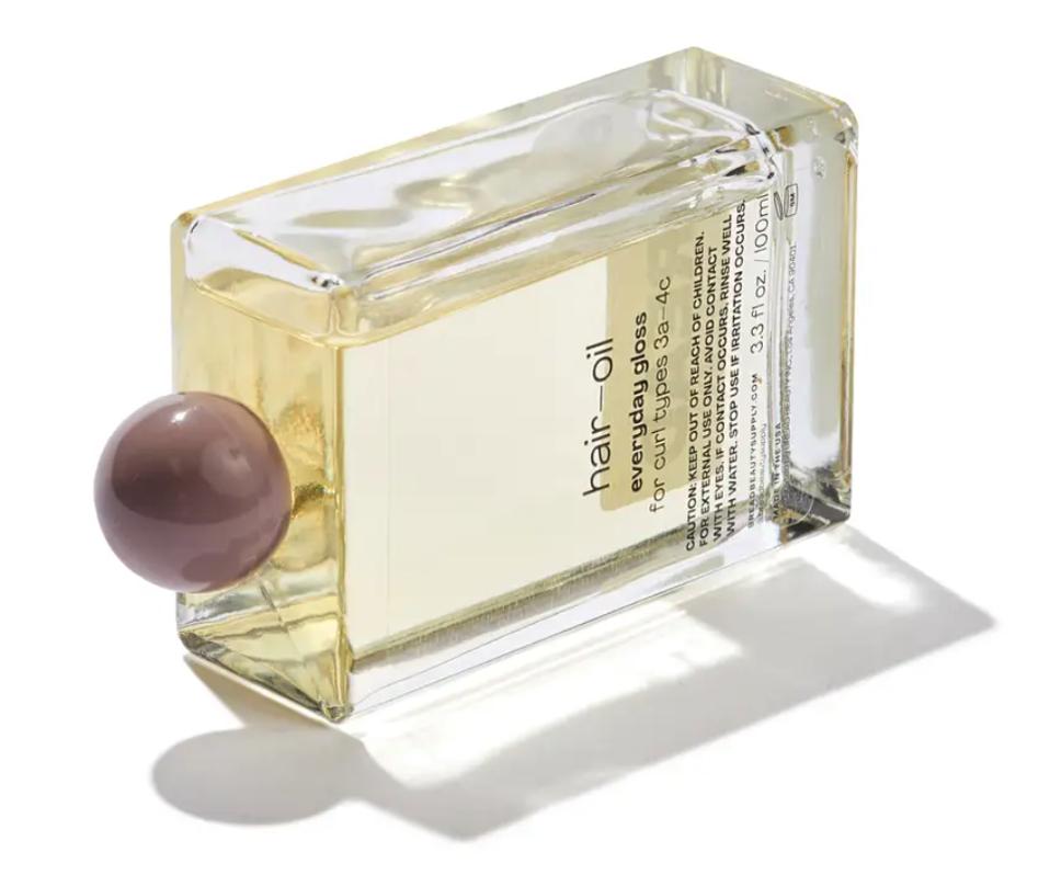 a bottle of hair oil in clear glass square bottle
