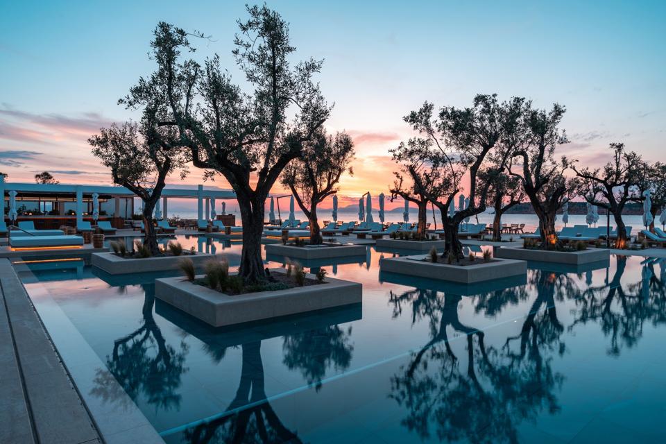 rees are reflected in the pool at Four Seasons Astir Palace on the Athens Riviera, Greece