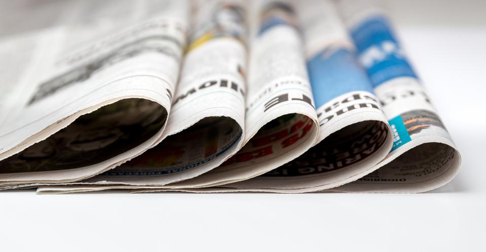 soft focus of newspapers folded and stacked in pile. Concept of print media, news and publishing industry