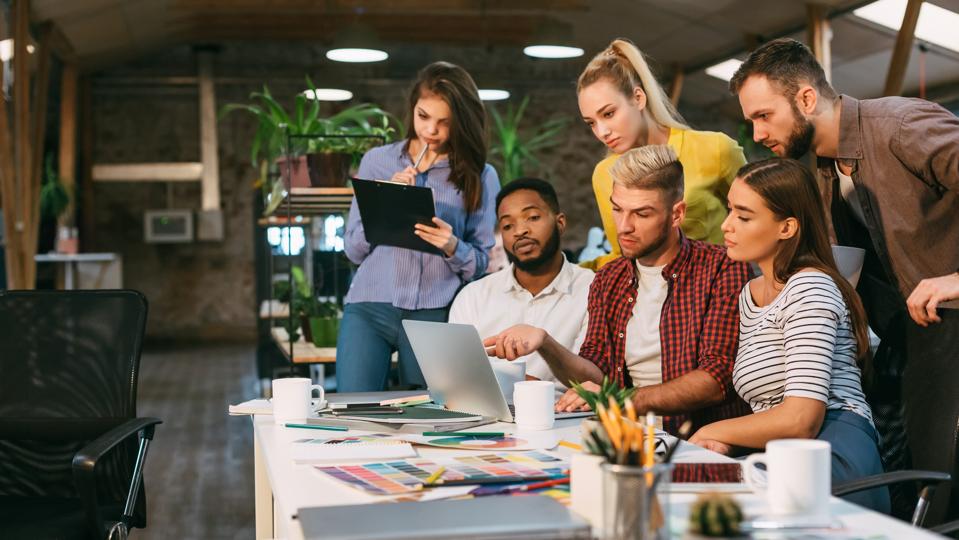 Agency coworkers discussing new project on laptop