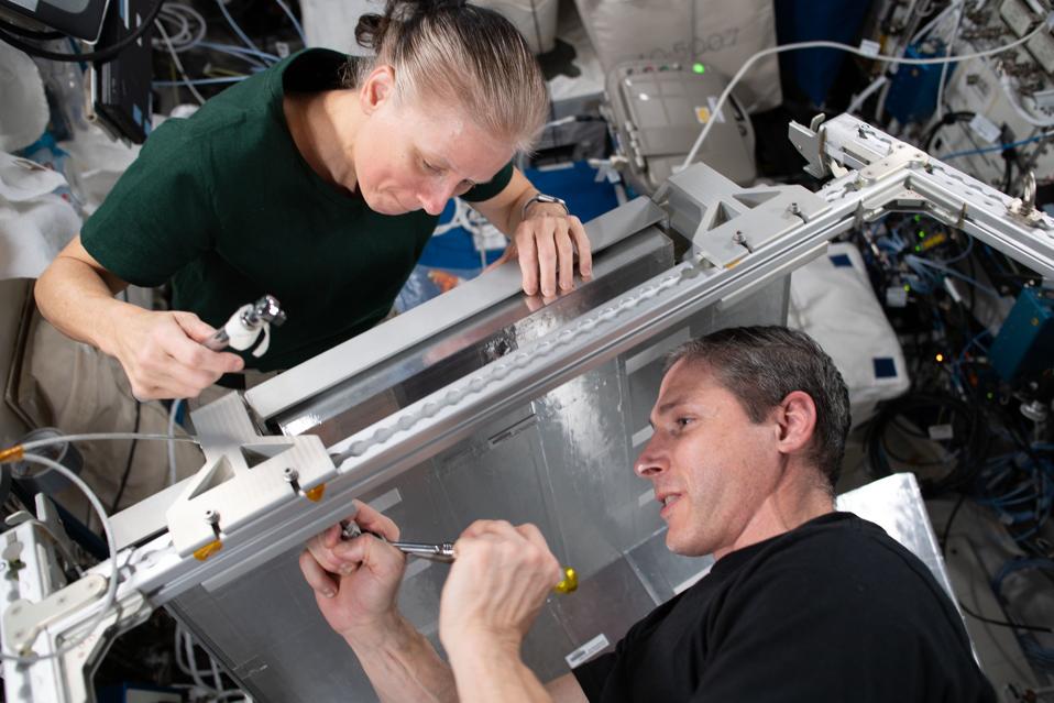 NASA Flight Engineers Shannon Walker and Michael Hopkins install temporary sleeping quarters inside the Columbus laboratory module from the European Space Agency. The new Crew Alternate Sleep Accommodation, which can also be converted to a cargo storage rack, will allow extra space for the short period when up to 11 crew members will be occupying the International Space Station in April.