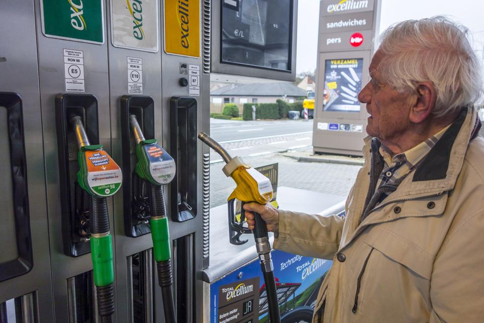 Elderly man selecting diesel fuel at gas station in Belgium, Europe.