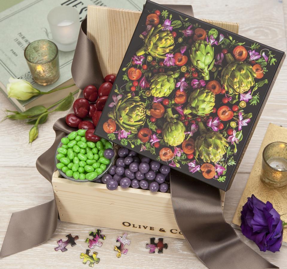 Un puzzle sur le thème du jardin avec des artichauts et des fleurs se trouve dans une boîte