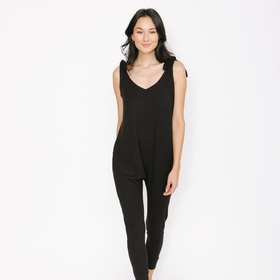 A woman wears a black Smash + Tess romper.