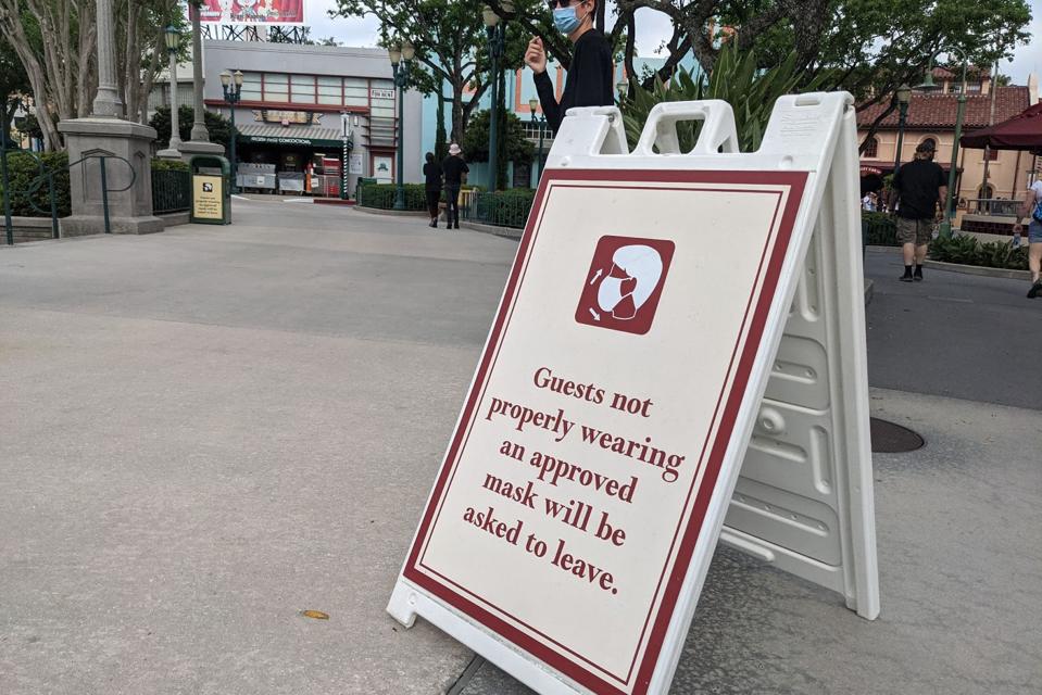 This is what it's like to travel to Florida now: A sign at Disney Studios warns visitors to keep their masks on or face expulsion.