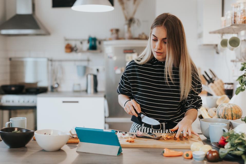 A girl learns how to cook while following recipe instructions.