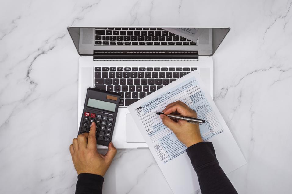 Filling Up Tax Form and Using Calculator and Laptop