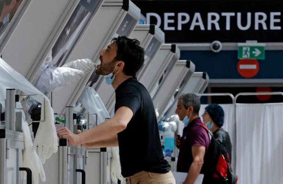A medic collects a swab sample from a traveller at a rapid COVID-19 testing booth in Israel's Ben Gurion Airport, near Tel Aviv, on April 6, 2021.