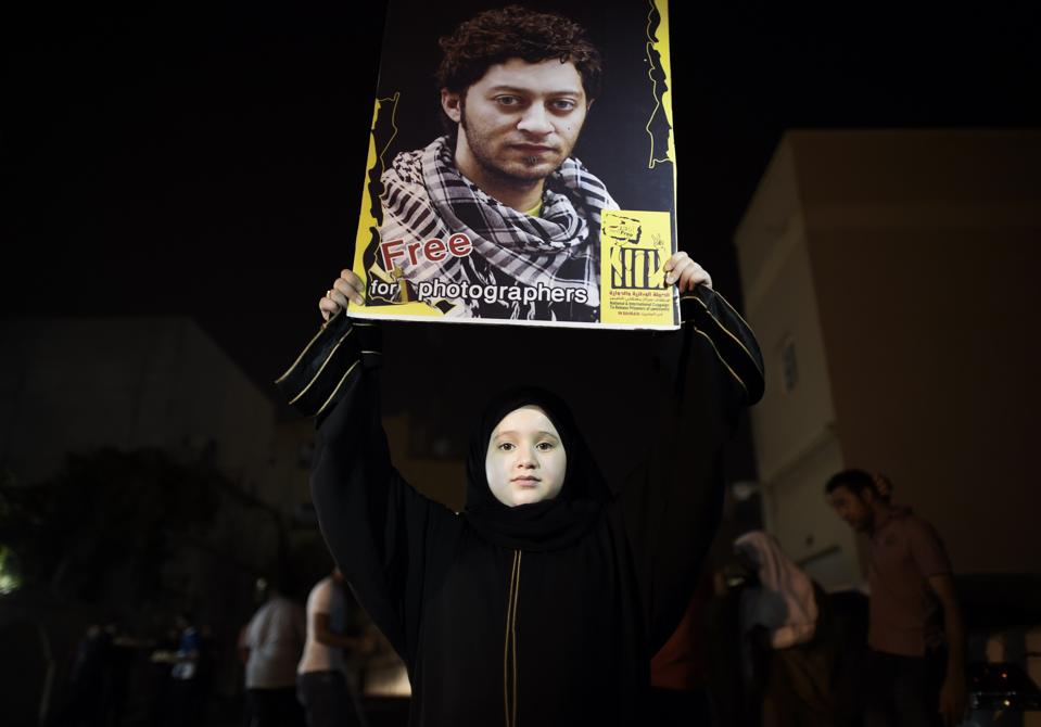 A Bahraini girl holds up a portrait of jailed Bahraini photographer Ahmed Humaidan.