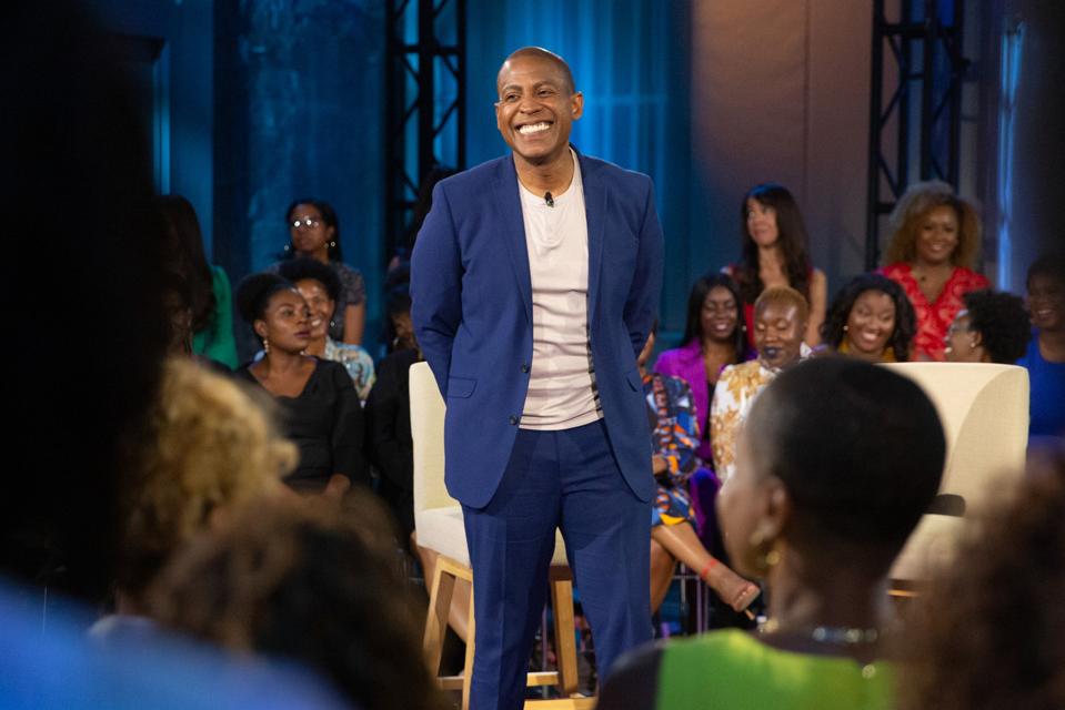 talk show host in a blue suit