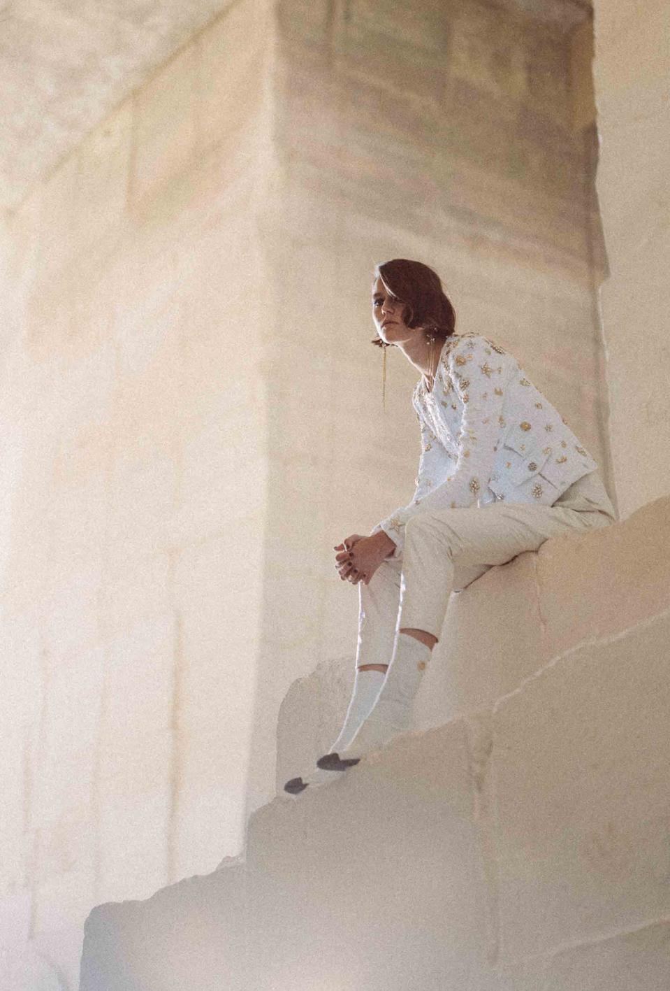 Vivienne Rohner is wearing a jacket in bright white tweed with symbolic charms