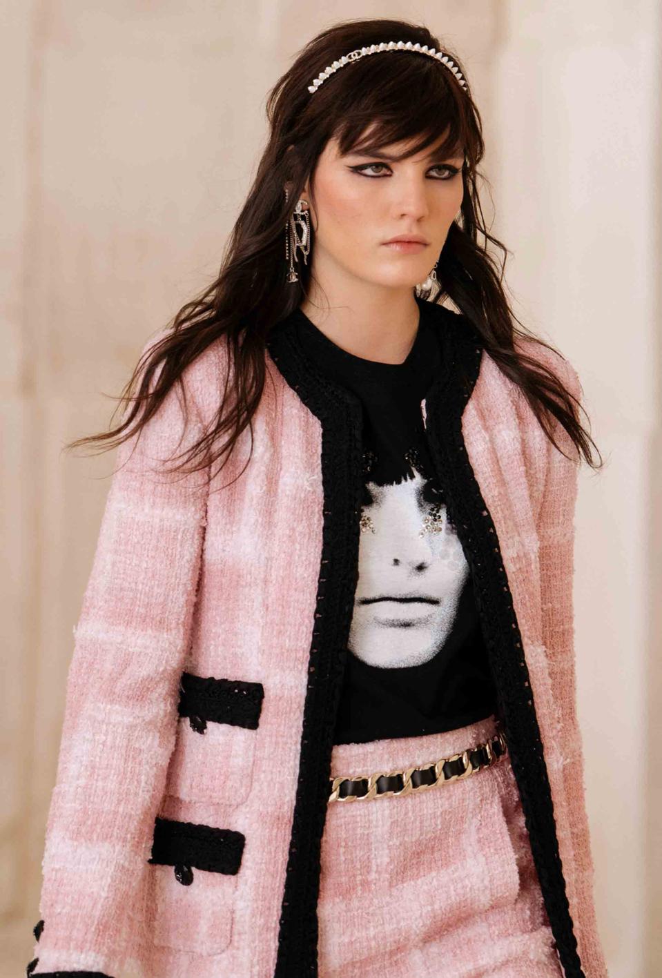 Lola Nicon is wearing a mini skirt suit in shaded pink tweed