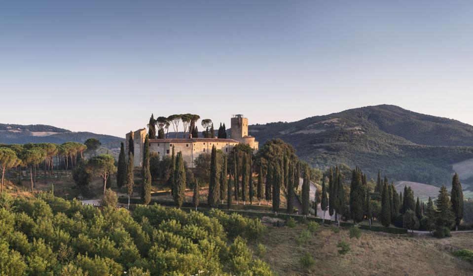 Un forte in pietra ai piedi circondato da verdi colline.