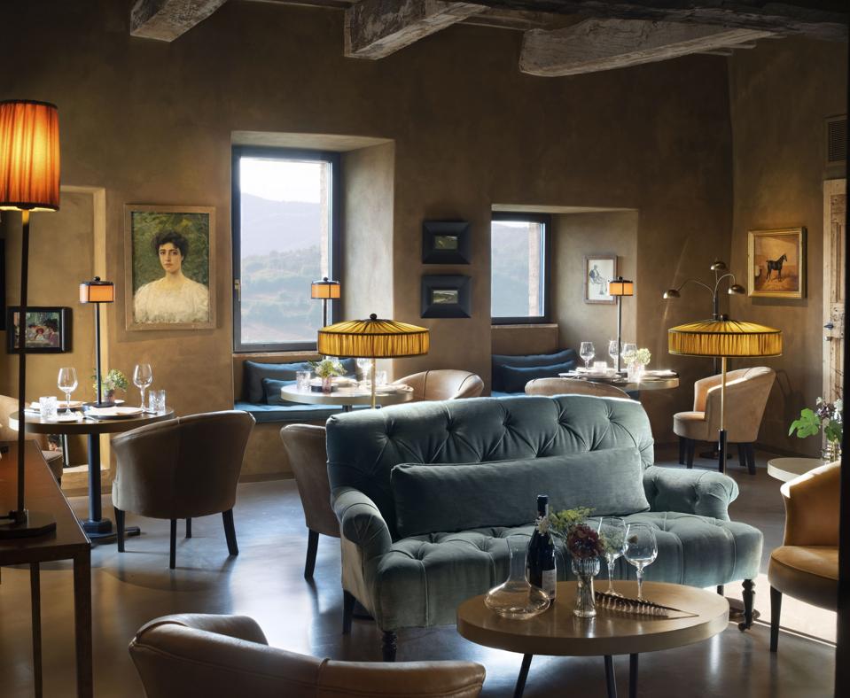 Un ristorante all'interno di muri in pietra con dipinti ad olio e divani imbottiti Sky Blue
