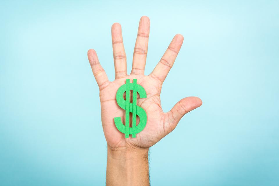 Main en montrant / attraper un symbole du dollar vert avec un fond bleu.