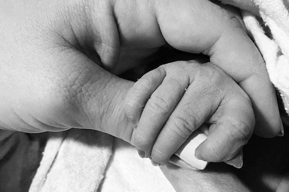Ashley Tisdale holding hands with her newborn daughter Jupiter