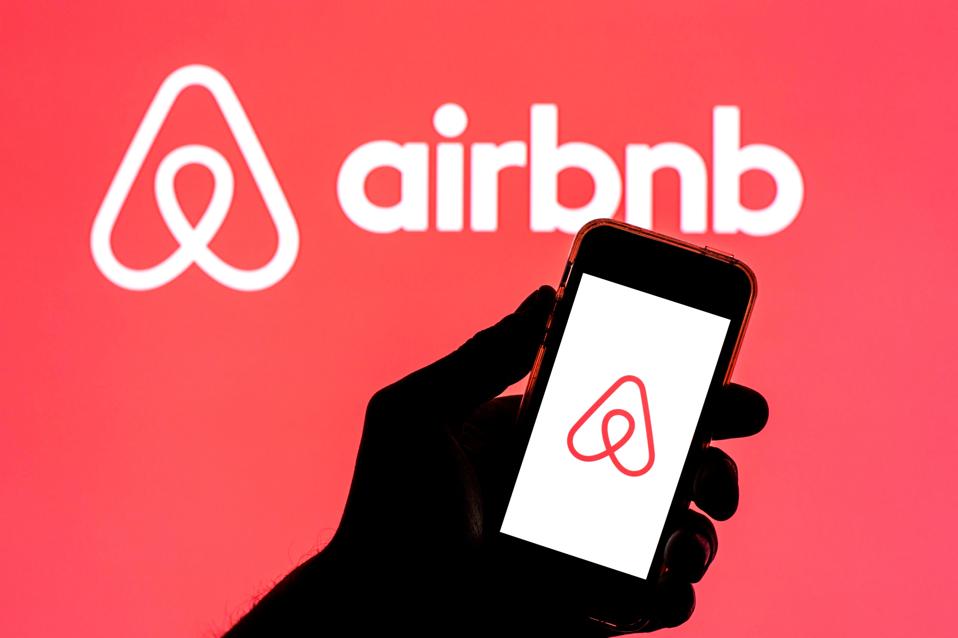In this photo illustration, the Airbnb app seen displayed on...