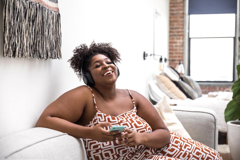 Woman relaxing at home listening to music