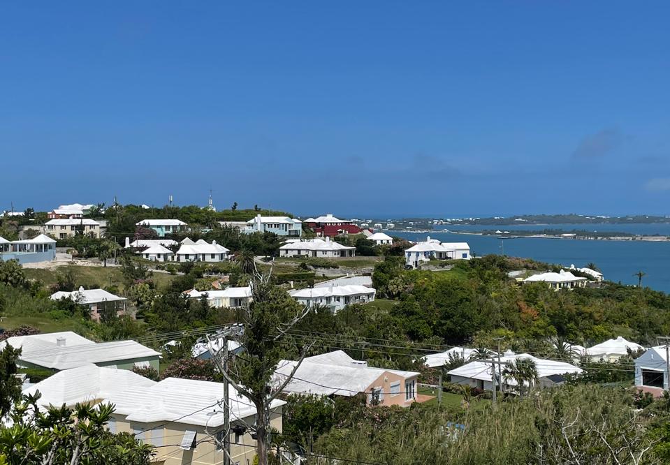 Driving along in Bermuda with pastel cottages and white stepped-roofs