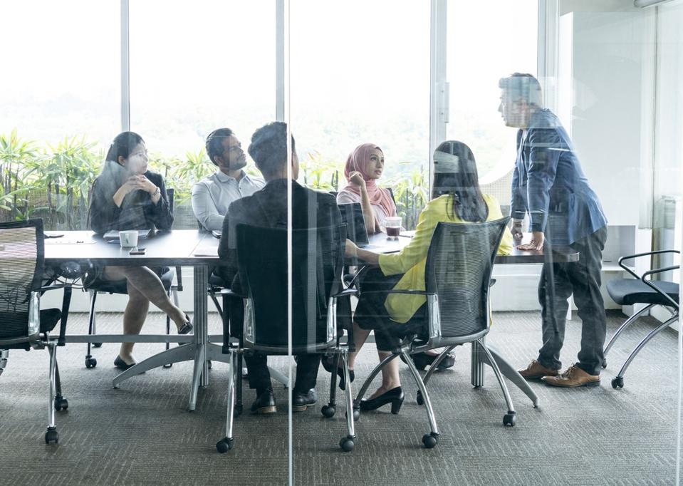 View through glass towards business meeting