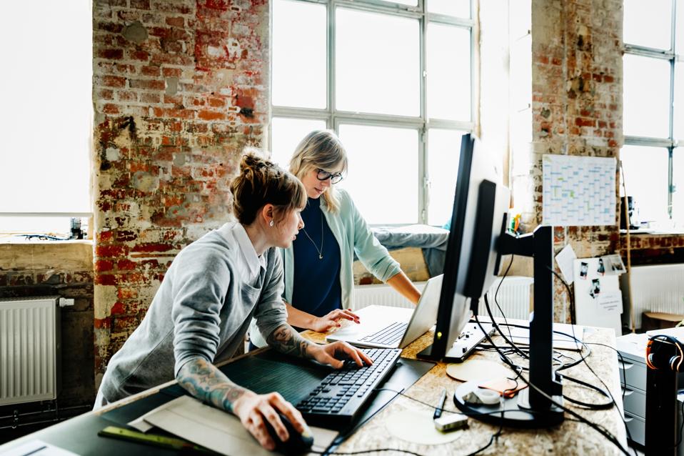 Two casual businesswomen working on computer