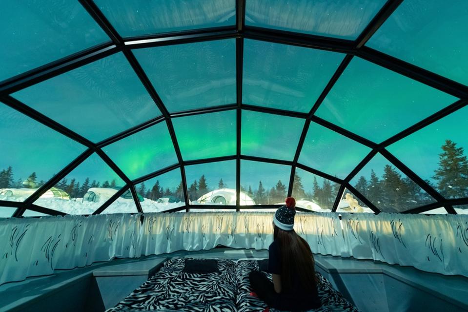 Aurora borealis shining in the night sky seen from Glass Igloos in Arctic Finland.