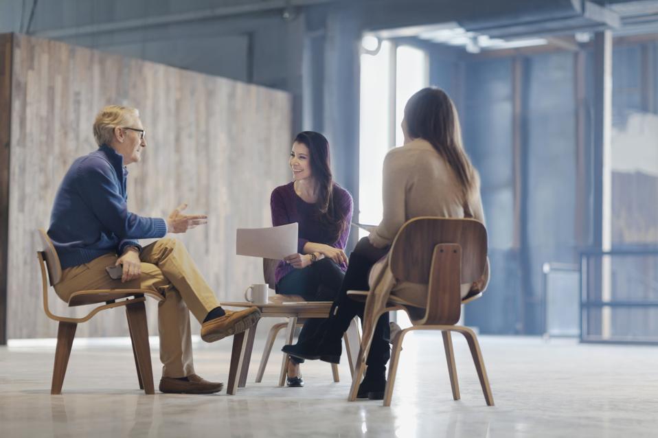Colleagues talking in meeting in lobby space