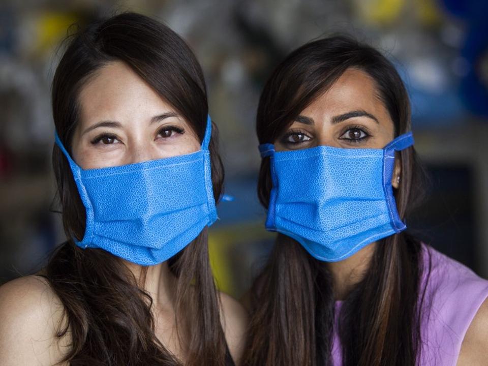 Two young women wearing blue face masks.