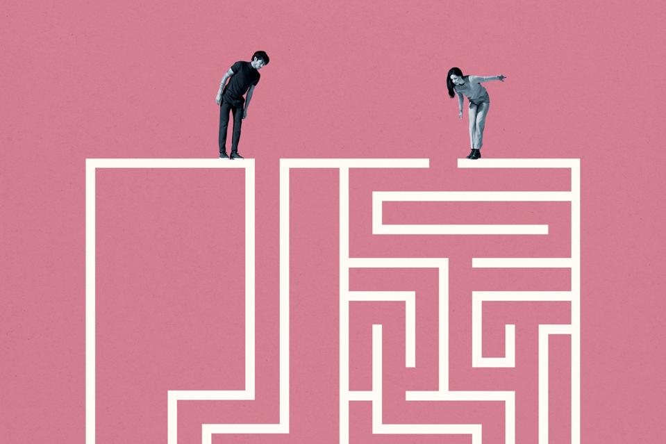 Young man and woman standing on top of white maze