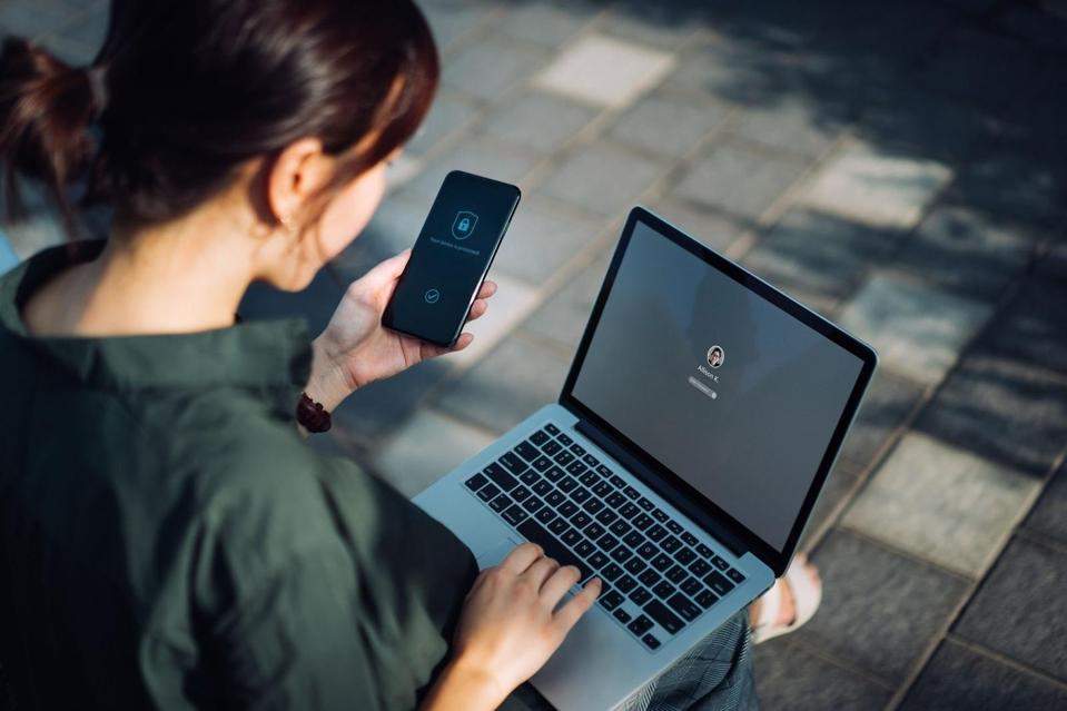 Women on her phone and computer outside