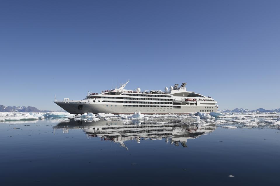 Le Soleal ship sails among icebergs.