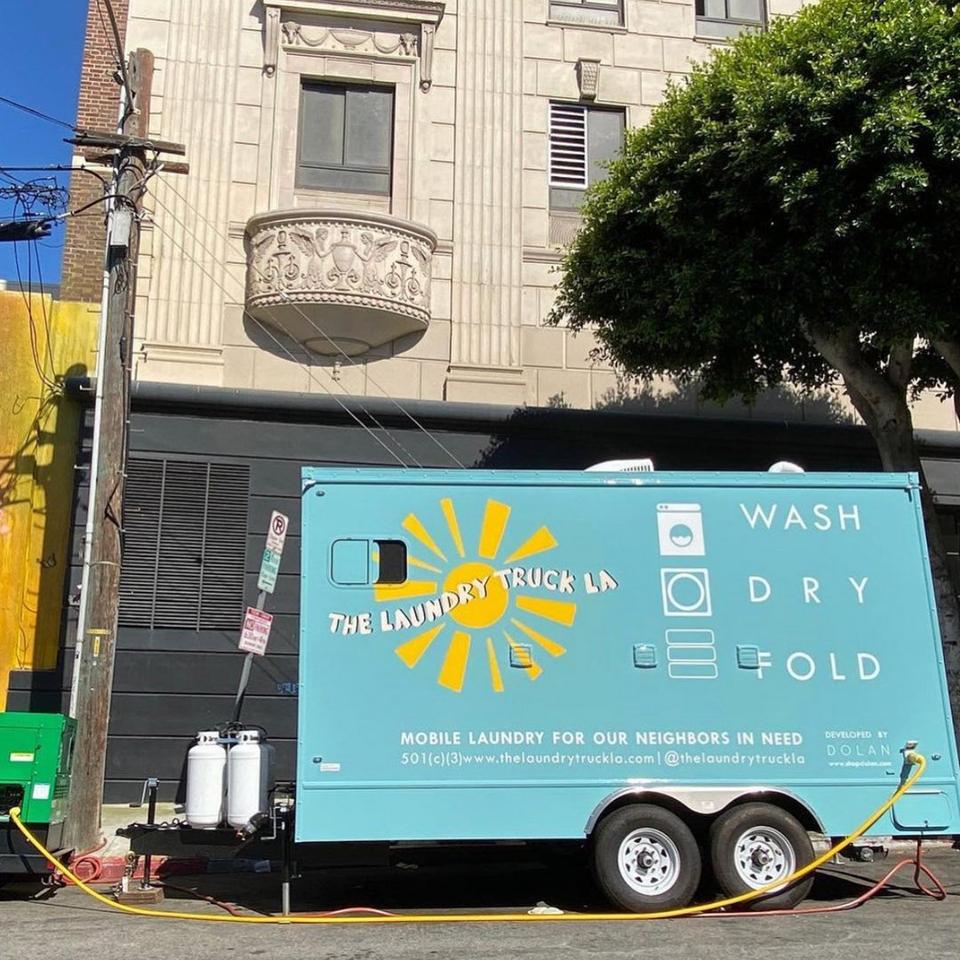 An aqua laundry truck with a sun on it that says ″The Laundry Truck LA″