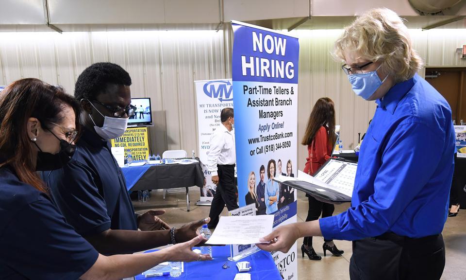 A man hands his resume to an employer at the 25th annual...