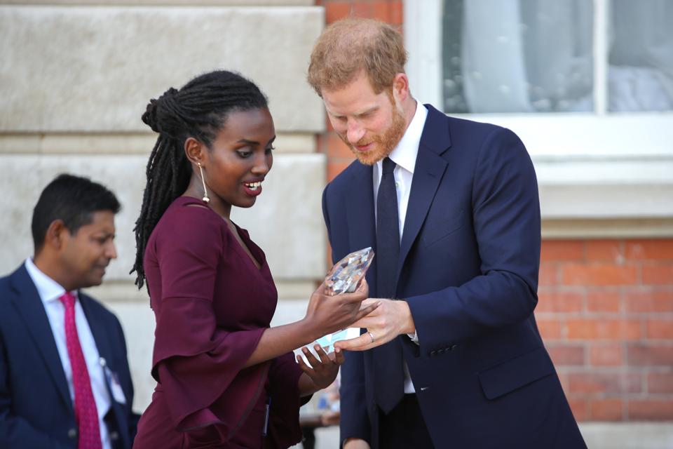 Rosette Muhoza receives an award from Prince Harry at a garden party in England.