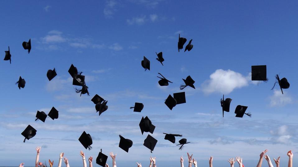 Graduation celebrations, throwing caps into a blue sky