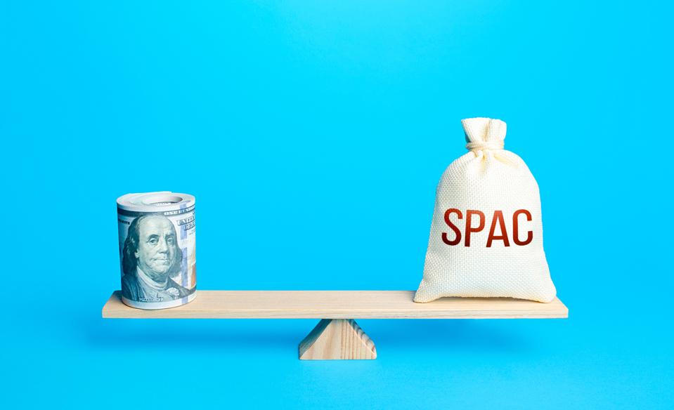 Bundle of dollars and a bag of SPAC on scales. The concept of attracting investors' money to fund the merger of companies into a new one. Assessing the value of the new company and profitability.