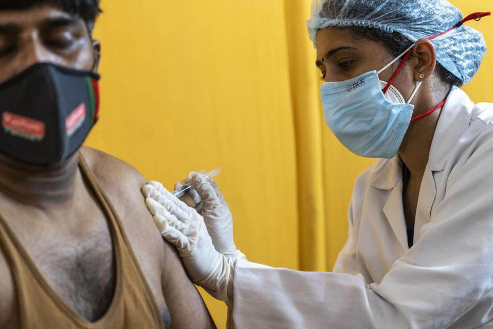 health worker in India vaccinating in New Delhi
