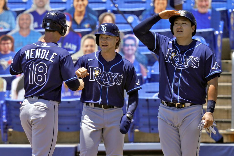 The Tampa Bay Rays' Joey Wendle is greeted at home plate by Taylor Walls and Ji-Man Choi.