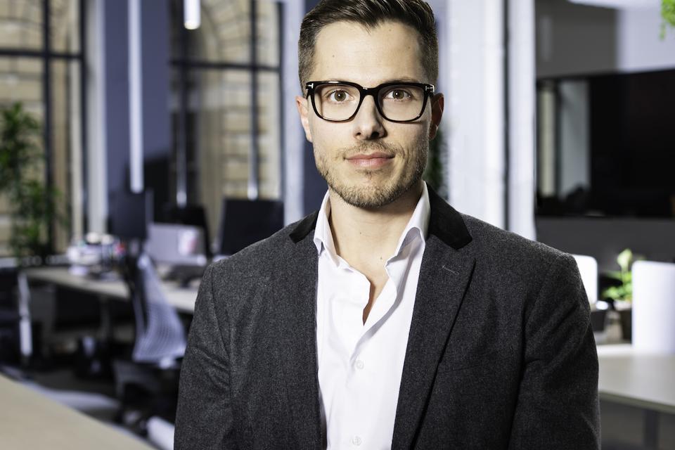 Max Leca, VP of Operations, Dialogue, pictured standing in the office.