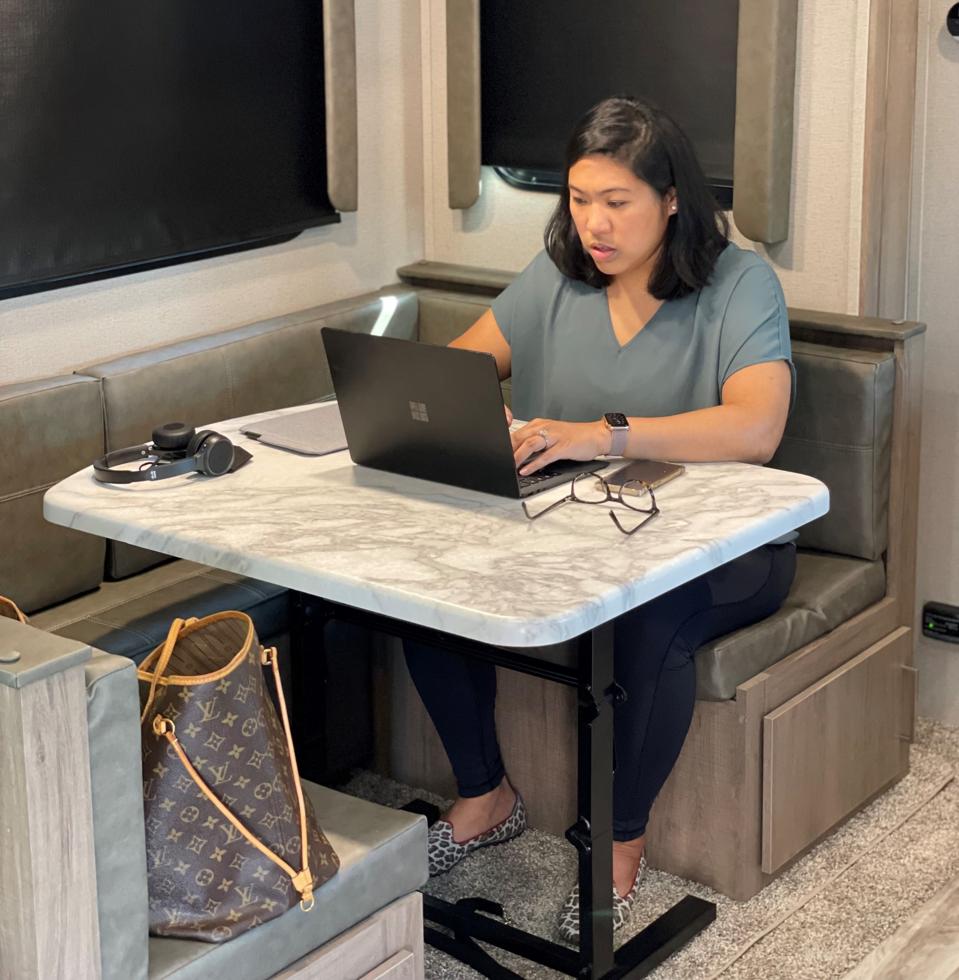 Woman working on computer insider travel trailer