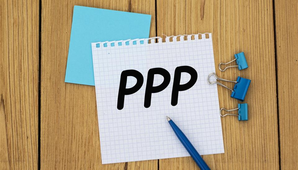 The letters ″PPP″ on a white sheet on a wooden background with a handle and clips