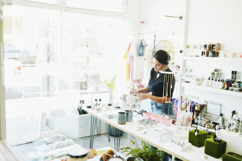 Female business owner organizing boutique before store opening