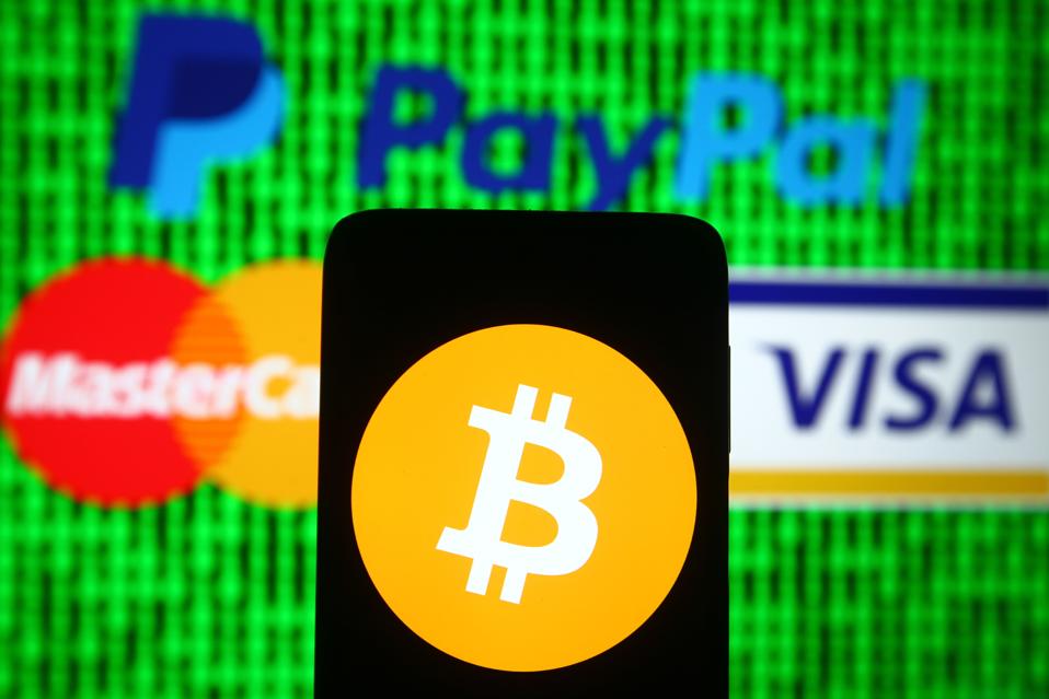 In this photo illustration a Bitcoin sign is seen on a...