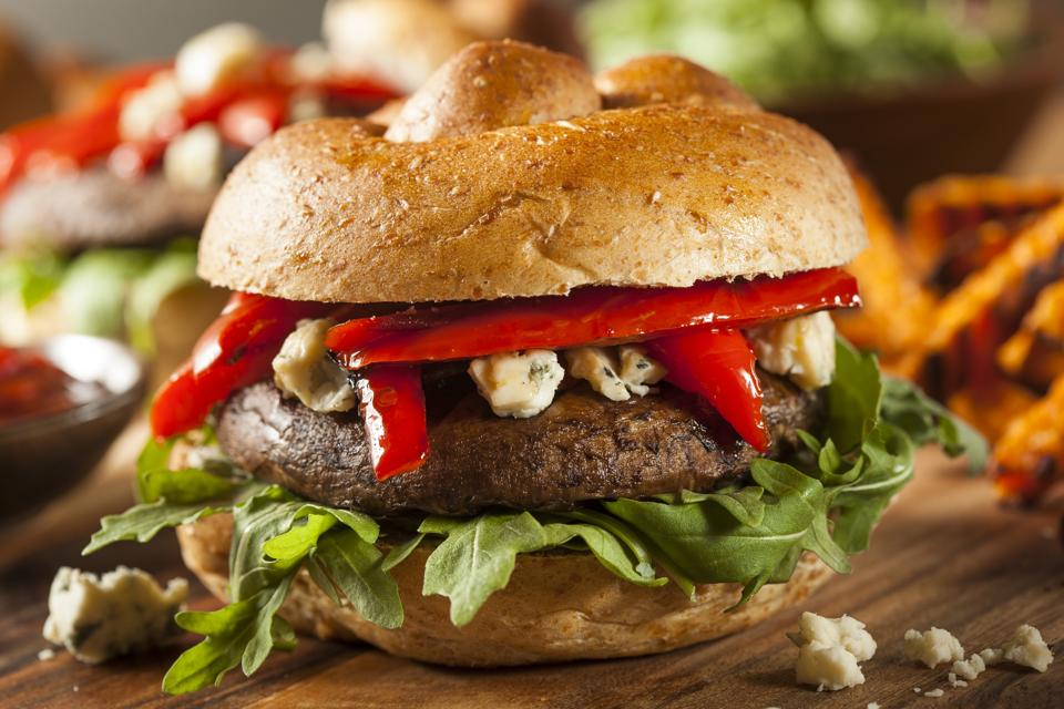Portobello burger topped with arugula cheese and peppers.