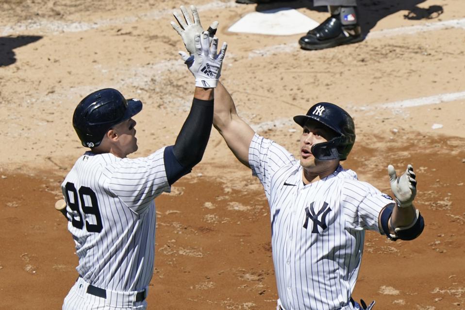 Aaron Judge and Giancarlo Stanton celebrate after Stanton hits a solo home run.