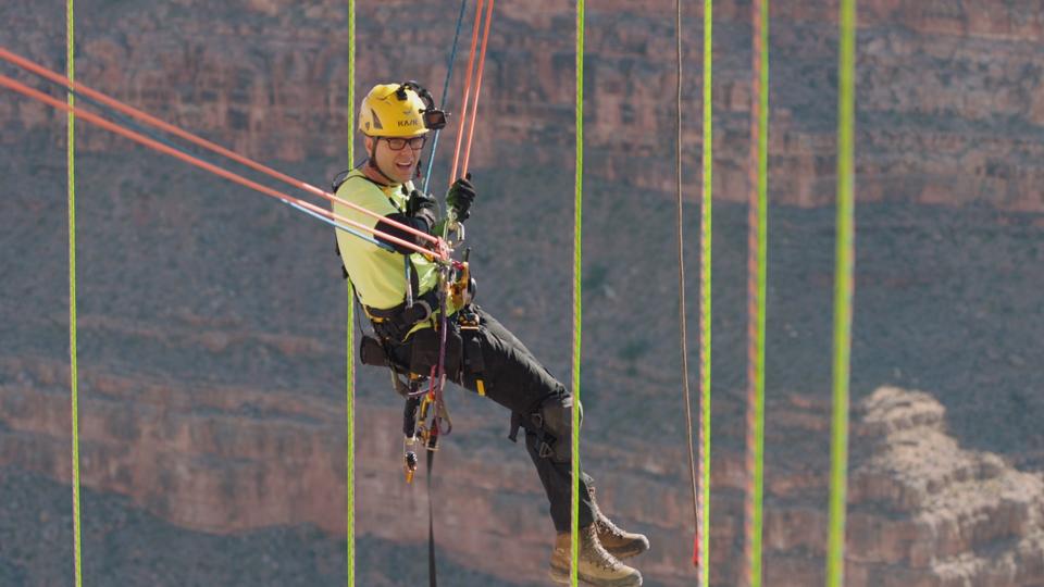AZ - Bobby Bones is pulled by a winch to return to the cliffside at the Skywalk at Grand Canyon West.