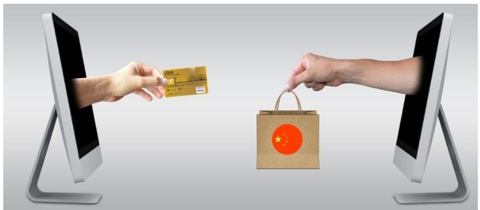 2 computers show forearms protruding, one with a credit card, other with a shopping bag.