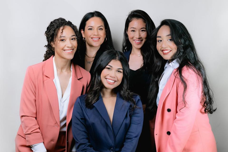 With ‘Cyber Collective,’ BIPOC Women Educate On Digital Data Privacy And Ethics Five women of color pose wearing pink, blue, and black blazers.